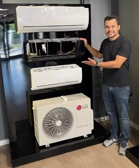 Técnico da PurificaAR fazendo a limpeza e higienização de um ar-condicionado